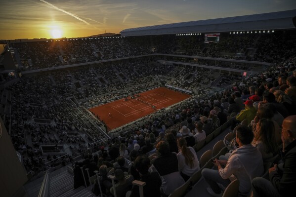 The sun sets during the second round match of the French Tennis Open between Denmark's Holger Rune and Emilio Nava of the United States at the Roland-Garros stadium in Paris, Wednesday, May 28, 2025. (AP Photo/Aurelien Morissard)