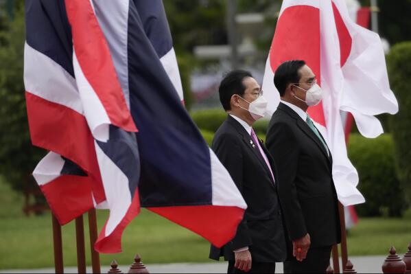 Japanese Prime Minister Fumio Kishida, left, and Thailand's Prime Minister Prayuth Chan-ocha listen to national anthems during a welcoming ceremony at the Government House in Bangkok, Thailand, Monday, May 2, 2022. (AP Photo/Sakchai Lalit)
