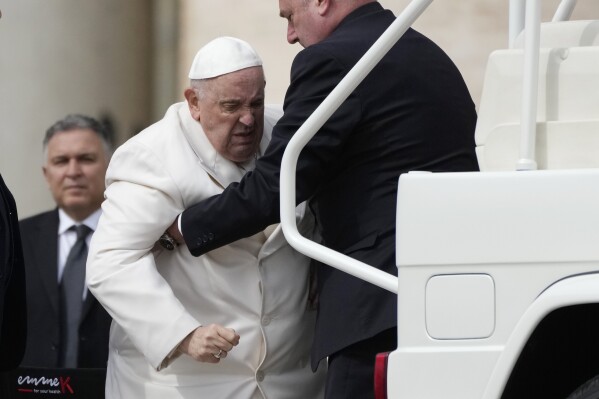 Pope Francis helped to get on his car at the end of weekly general audience in St. Peter's Square, at the Vatican, March 29, 2023. (AP Photo/Alessandra Tarantino)