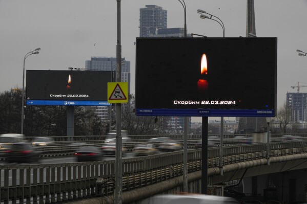 Traffic on the highway passes a message displayed on a billboard that reads: "We Mourn 03.22.2024" in Moscow, Russia, Saturday, March 23, 2024, following an attack Friday, for which the Islamic State group claimed responsibility. Russian officials say more than 90 people have been killed by assailants who burst into a concert hall and sprayed the crowd with gunfire. (AP Photo/Alexander Zemlianichenko)