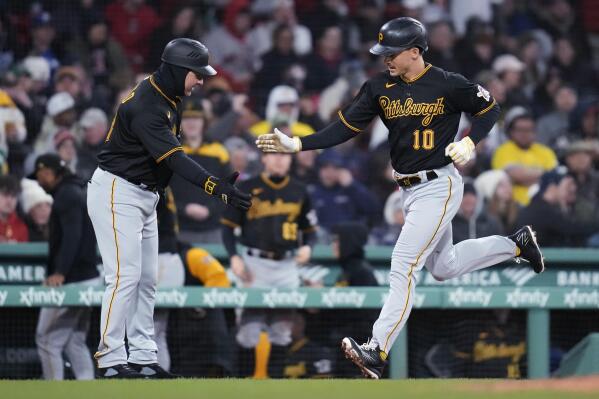 Pittsburgh Pirates' Bryan Reynolds (10) is congratulated by third base coach Mike Rabelo after his solo home run off Boston Red Sox starting pitcher Kutter Crawford during the fourth inning of a baseball game at Fenway Park, Monday, April 3, 2023, in Boston. (AP Photo/Charles Krupa)