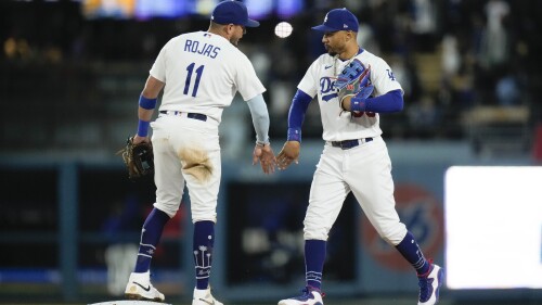 Los Angeles Dodgers' Miguel Rojas (11) and Mookie Betts celebrate the team's win against the Houston Astros in a baseball game Friday, June 23, 2023, in Los Angeles. (AP Photo/Jae C. Hong)