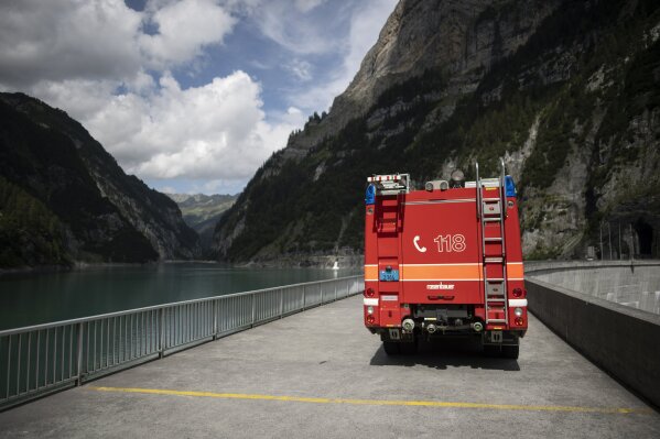 A road is blocked block on the Gigerwald reservoir dam in Vaettis, Switzerland, Thursday, August 13, 2020. The road is blocked due to a ongoing search-and-rescue mission after a canyoning accident ...