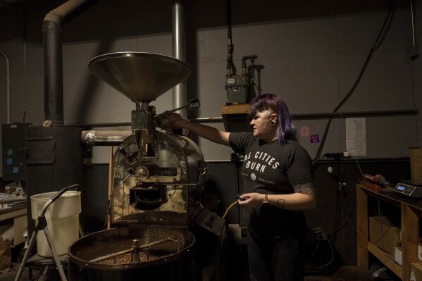 Renee Colon, co-owner of Fuego Coffee Roasters, operates her roasting machine, Friday, March 21, 2025, in Rochester, N.Y. (Max Conway via AP)