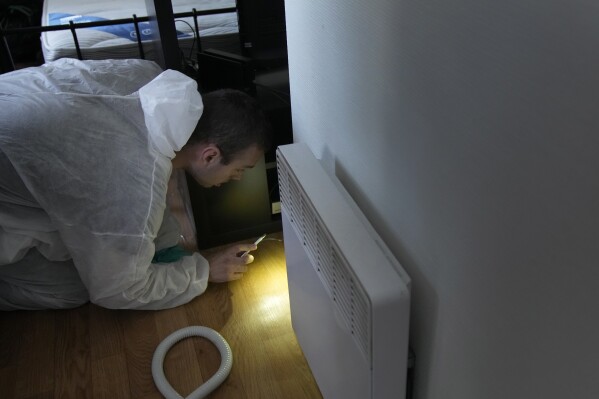 Pest control technician Lucas Pradalier looks for bedbugs in a Paris apartment, Wednesday, Oct. 4, 2023. The French government has been forced to step in to calm a nation increasingly anxious about bedbugs. (AP Photo/Christophe Ena)