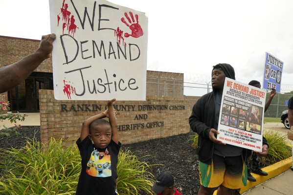 FILE - An anti-police brutality activist looks back at the entrance to the Rankin County Sheriff's Office in Brandon, Miss., Wednesday, July 5, 2023, as the group called for the termination and prosecution of Rankin County Sheriff Bryan Bailey for running a law enforcement department that allegedly terrorizes and brutalizes minorities. Six former Mississippi law officers, including some who call themselves the 