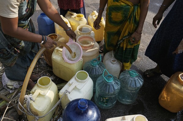 People filter water as they collet it from a public tap in Hyderabad, India, Friday, March 22, 2024. (AP Photo/Mahesh Kumar A.)
