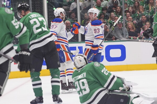 Edmonton Oilers center Ryan Nugent-Hopkins (93) celebrates his goal with teammate Connor McDavid (97) as Dallas Stars goaltender Jake Oettinger (29) and defenseman Esa Lindell (23) look on during the second period in Game 1 of the Western Conference finals in the NHL hockey Stanley Cup playoffs Wednesday, May 21, 2025, in Dallas. (AP Photo/LM Otero)