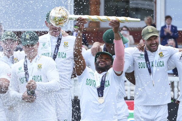South Africa's captain Temba Bavuma holds the winner's trophy and celebrates with teammates after their win in the World Test Championship final against Australia at Lord's cricket ground in London, Saturday, June 14, 2025. (AP Photo/Kirsty Wigglesworth)