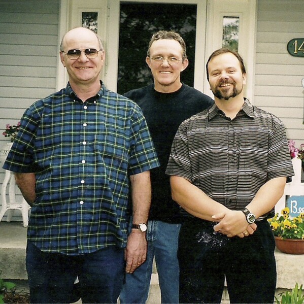 This photo provided by the family shows Brian Hays, center, of Muscatine, Iowa, with his two brothers. In time, Hays' wife, Sandra Jones, managed to get Hays' autopsy report from the medical examiner’s office, confirming the use force and a struggle in 2015. But an attorney told her winning a lawsuit to pry out more information was unlikely. His death didn’t even make the local news. “All I know is, something terrible happened that night,” she said. “I have pictured him laying on that cement road more times than I can tell you. I picture him there, struggling to breathe.” (Courtesy Sandra Jones via AP)