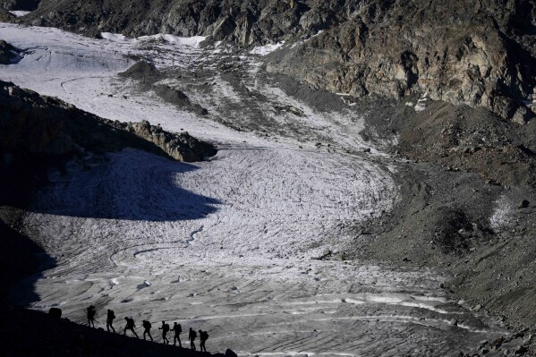 FILE - A group of hikers is on the way to the Jamtalferner Glacier near Galtuer, Austria, on Sept. 6, 2023. Austrian glaciers receded last year at a rapid pace, and the Alpine country is likely to be largely ice-free in 40 to 45 years as the process continues, experts said Friday April 5, 2024. (AP Photo/Matthias Schrader, File)
