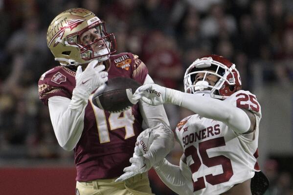 Florida State wide receiver Johnny Wilson (14) makes a reception while defended by Oklahoma defensive back Justin Broiles (25) during the second half of the Cheez-It Bowl NCAA college football game, Thursday, Dec. 29, 2022, in Orlando, Fla. (AP Photo/Phelan M. Ebenhack)