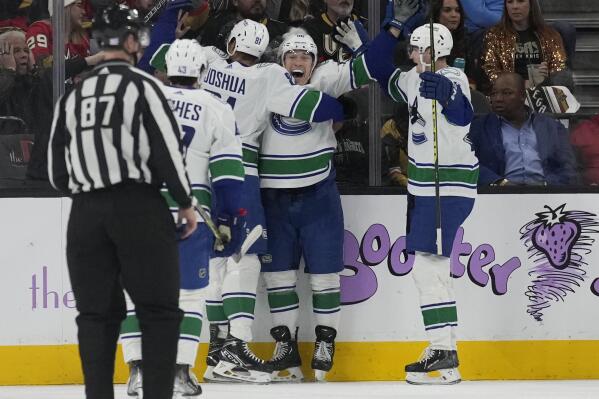 Vancouver Canucks left wing Andrei Kuzmenko, second from right, celebrates after scoring against the Vegas Golden Knights during the second period of an NHL hockey game Saturday, Nov. 26, 2022, in Las Vegas. (AP Photo/John Locher)