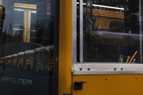 Writing utensils are seen in the window of a diesel school bus inside a Montgomery County school bus in Rockville, MD, on Friday, February 9, 2024.  Diesel exhaust from school buses affects one-third of American students, their parents, and  Teacher every day.  (AP Photo/Tom Brenner)