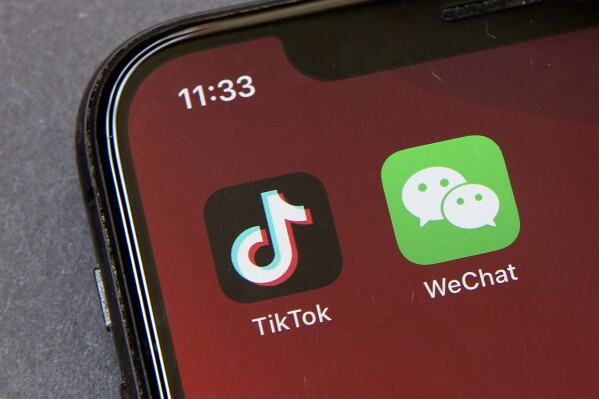 FILE - Icons for the smartphone apps TikTok and WeChat are seen on a smartphone screen in Beijing, on Aug. 7, 2020. An Australian Senate committee has on Wednesday, Aug. 2, 2023, recommended a ban on the Chinese-owned video-sharing app TikTok from federal government devices be extended to China's most popular social media platform, WeChat. (AP Photo/Mark Schiefelbein, File)