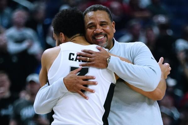 Providence coach Ed Cooley, right, hugs guard Matteus Case as he comes off the court during the second half of the team's college basketball game against Richmond in the second round of the NCAA men's tournament Saturday, March 19, 2022, in Buffalo, N.Y. (AP Photo/Frank Franklin II)