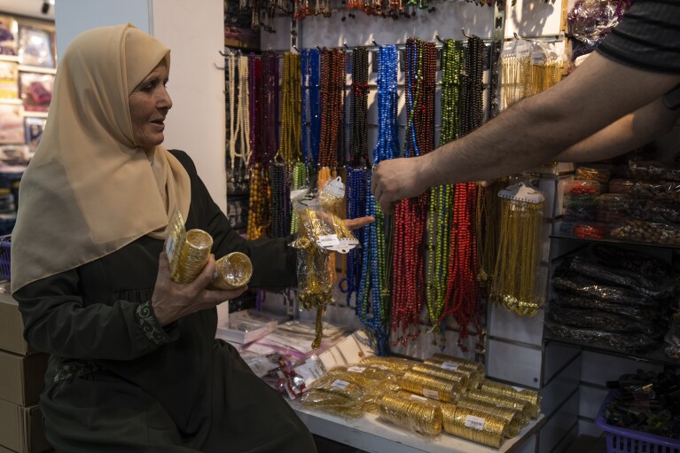 Huda Zaqqout shops for Hajj a few weeks before she travels to Mecca for the Muslim pilgrimage in Gaza City Wednesday, May 31, 2023. (AP Photo/Fatima Shbair)