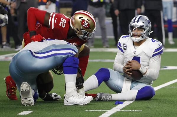 Dallas Cowboys quarterback Dak Prescott, right, holds the ball after recovering his own fumble on a sack by San Francisco 49ers defensive end Charles Omenihu (92) during the second half of an NFL wild-card playoff football game in Arlington, Texas, Sunday, Jan. 16, 2022. (AP Photo/Roger Steinman)