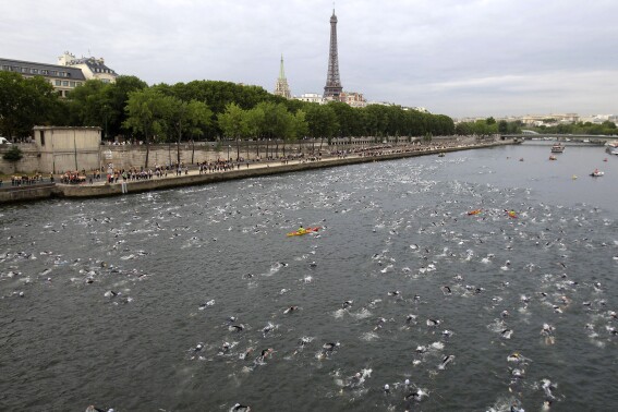 FILE - Competitors swim in the Seine River during the Paris Triathlon competition in Paris Sunday, July 10, 2011. Paris mayor Anne Hidalgo saidTuesday April 23, 2024 she was confident water quality will be up to the Olympics standards this summer _ and that she'll be able to prove it by swimming there, possibly alongside President Emmanuel Macron. (AP Photo/Lionel Cironneau, File )