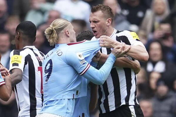 Manchester City's Erling Haaland, left, argues with Newcastle's Dan Burn during the English Premier League soccer match between Manchester City and and Newcastle, at the Etihad stadium in Manchester, England, Saturday, March 4, 2023. (AP Photo/Dave Thompson)