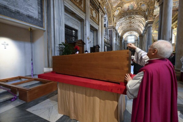 El jefe de la casa papal, Monseñor Leonardo Sapienza, coloca un sello en el ataúd que contiene el cuerpo del difunto papa Francisco durante la ceremonia de entierro en la Basílica de Santa María la Mayor en Roma, el sábado 26 de abril de 2025. (Vatican Media vía AP)