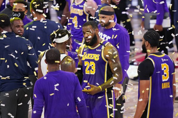 Los Angeles Lakers' LeBron James (23) talks with players as confetti falls after the Lakers beat the Denver Nuggets in an NBA conference final playoff basketball game Saturday, Sept. 26, 2020, in Lake Buena Vista, Fla. The Lakers won 117-107 to win the series 4-1. (AP Photo/Mark J. Terrill)