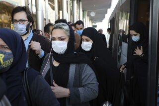 FILE - In this Sunday, Oct. 11, 2020 file photo, people wear protective face masks to help prevent the spread of the coronavirus in downtown Tehran, Iran. For the third time in a week, Iran on Wednesday marked its highest single-day record for new deaths and infections from the coronavirus, with 279 people killed and 4,830 new patients. (AP Photo/Ebrahim Noroozi, File)