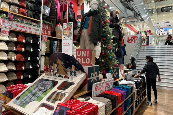 Shoppers looks at items displayed at the Uniqlo stores in New York on Sunday, Nov. 19, 2023. Retailers are kicking off the unofficial start of the holiday shopping season on Friday with a bevy of discounts and other enticements. (AP Photo/Anne D'Innocenzio)