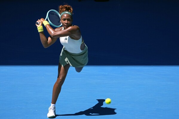 Coco Gauff of the U.S. plays a backhand return to Sofia Kenin of the U.S. during their first round match at the Australian Open tennis championship in Melbourne, Australia, Monday, Jan. 13, 2025. (AP Photo/Asanka Brendon Ratnayake)