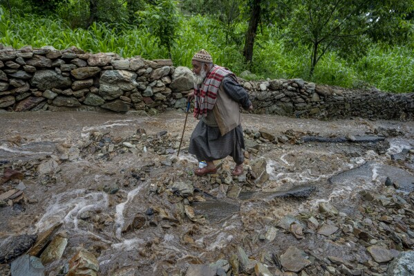 FILE - An elderly Kashmiri man walks on a road damaged by flash floods after a cloudburst on the outskirts of Srinagar, Indian controlled Kashmir, July 22, 2023. Such intense rainfall events, especially when more than 10 centimeters (3.94 inches) of rainfall occurs within a 10 square kilometers (3.86 square miles) region within an hour are called cloudbursts and have potential to wreak havoc, causing intense flooding and landslides that affect thousands in mountain regions. (AP Photo/Dar Yasin, File)