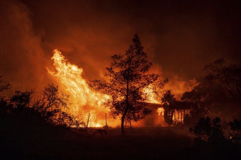 A structure is engulfed in flames as a wildfire called the Highland Fire burns in Aguanga, Calif., Monday, Oct. 30, 2023. A wildfire fueled by gusty Santa Ana winds ripped through rural land southeast of Los Angeles on Monday, forcing thousands of people from their homes, fire authorities said. (AP Photo/Ethan Swope)