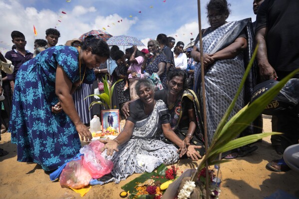 An ethnic Tamil war survivor is consoled by others as she cries for her deceased family members during a remembrance ceremony on a small strip of land where thousands of civilians were trapped during the last stages of the country's civil war in Mullivaikkal, Sri Lanka, Saturday, May 17, 2024. (AP Photo/Eranga Jayawardena)