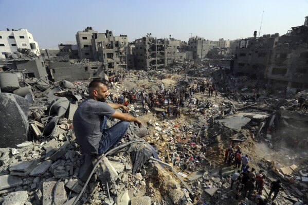 FILE - A man sits on the rubble overlooking the debris of buildings that were targeted by Israeli airstrikes in the Jabaliya refugee camp, northern Gaza Strip, Nov. 1, 2023. The White House says Israel has agreed to put in place four-hour daily humanitarian pauses in its assault on Hamas in northern Gaza. (AP Photo/Abed Khaled, File)