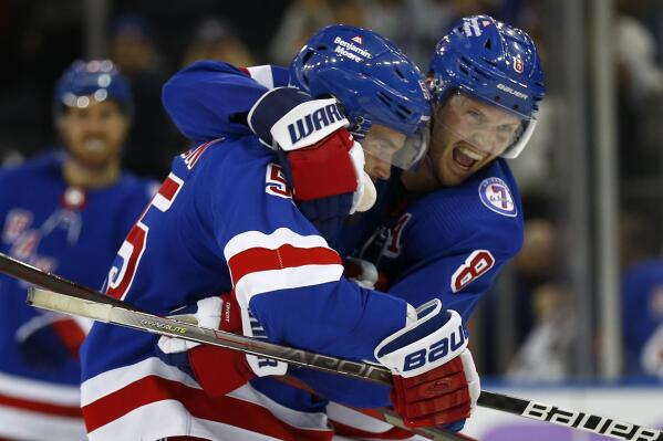 After scoring the winning goal, New York Rangers' Ryan Lindgren (55) gets a hug from teammate Jacob Trouba (8) during the third period of an NHL hockey game against the Buffalo Sabres, Sunday, Nov. 21, 2021, in New York. (AP Photo/John Munson)