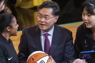 In this photo released by Xinhua News Agency, Qin Gang, then ambassador to the United States, center, talks to players before a WNBA 2022 regular season match between New York Liberty and Chicago Sky, in New York on July 23, 2022. China's new Foreign Minister Qin Gang is starting his term with a weeklong trip to five African countries, the Foreign Ministry announced Monday, Jan. 9, 2023. (Michael Nagle/Xinhua via AP)