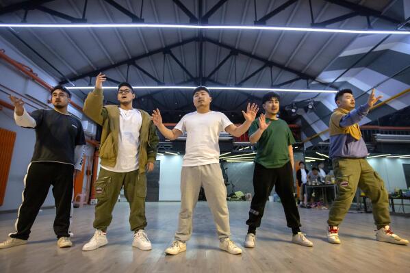 Members of the Chinese music group Produce Pandas, from left, DING, Husky, Otter, Cass, and Mr. 17 strike a pose while practicing dance choreography during rehearsals in Beijing, Thursday, April 15, 2021. The Produce Pandas proudly call themselves "the first plus-sized boy band in China." That's a radical departure from the industry standard set by Korean super groups such as BTS, whose lanky young members are sometimes referred to in China as "little fresh meat." (AP Photo/Mark Schiefelbein)