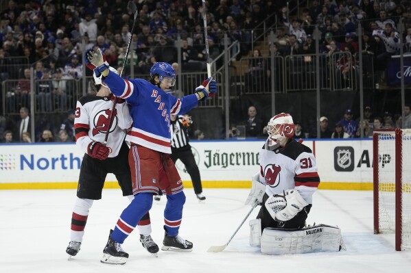 New York Rangers' Matt Rempe, center, reacts after teammate Erik Gustafsson scored on New Jersey Devils goaltender Kaapo Kahkonen (31) during the second period of an NHL hockey game, Monday, March 11, 2024, in New York. (AP Photo/Seth Wenig)