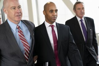 FILE--In this April 1, 2019, file photo, former Minneapolis police officer Mohamed Noor, center, leaves the Hennepin County Government Center after the first day of jury selection with his attorneys Thomas Plunkett, left, and Peter Wold, in Minneapolis, Minn. Testimony in Noor's trial has shined a light on officers' actions at the scene and raised questions about whether they were trying to protect one of their own. The incident commander turned her body camera off when talking to Noor in the moments after the July 2017 shooting of Justine Ruszczyk Damond, while other officers who responded told him not to say a word, according to prosecutors and court testimony. (Renee Jones Schneider/Star Tribune via AP, File)