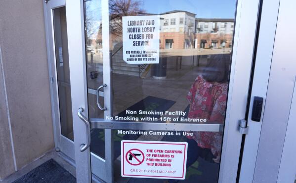 Signs are placed on the outside doors of city hall to advise visitors that the library as well as a restroom are closed because of meth contamination Thursday, Jan. 12, 2022, in the south Denver suburb of Englewood, Colo. (AP Photo/David Zalubowski)