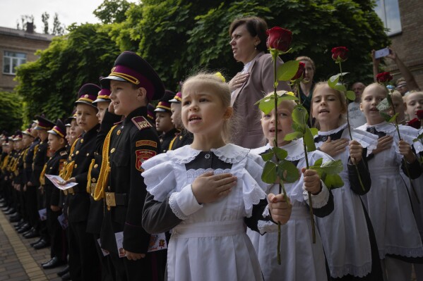 Young cadets sing the national anthem during a graduation ceremony in a cadet lyceum in Kyiv, Ukraine, Tuesday, June 13, 2023. (AP Photo/Efrem Lukatsky)