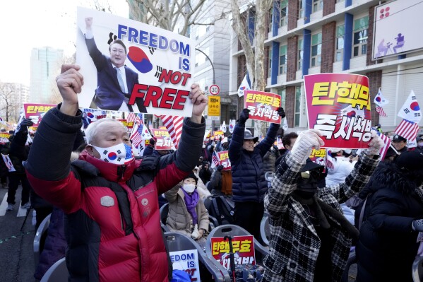Supporters of impeached South Korean President Yoon Suk Yeol hold signs during a rally to oppose his impeachment near the Constitutional Court in Seoul, South Korea, Thursday, Feb. 13, 2025. The letters read "Nullity Impeachment." (AP Photo/Lee Jin-man)
