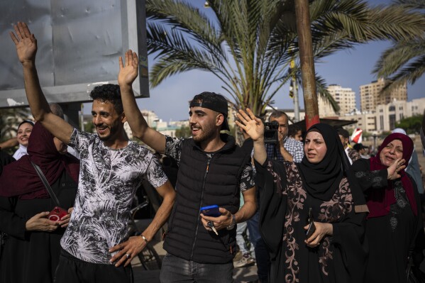 Relatives of Huda Zaqqout wave to say goodbye as she leaves Gaza City for the Hajj pilgrimage in the holy city of Mecca, Tuesday, June 13, 2023. (AP Photo/Fatima Shbair)