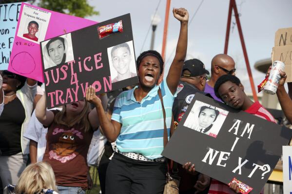 In this March 22, 2012 file photo, protestors, Lakesha Hall, of Sanford, center, and her son, Calvin Simms, right, participate in a rally for Trayvon Martin, the black teenager who was fatally shot by George Zimmerman, a neighborhood watch captain in Sanford, Fla. The killing of Trayvon Martin at the hands of a stranger still reverberates 10 years later -- in protest, in partisanship, in racial reckoning and reactionary response, in social justice and social media. (AP Photo/Julie Fletcher, File)