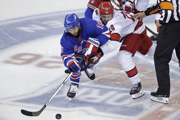 New York Rangers center Vincent Trocheck (16) and Carolina Hurricanes center Sebastian Aho (20) battle for the puck in the third period during Game 5 of an NHL hockey Stanley Cup second-round playoff series Monday, May 13, 2024, in New York. (AP Photo/Adam Hunger)