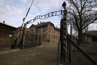 FILE - A view of the gate of the Auschwitz Nazi death camp in Oswiecim, Poland, Jan. 27, 2020.  he Auschwitz-Birkenau museum says it has been targeted with the use of “primitive” propaganda after disinformation spread on Russian social media posts. The museum said Friday, June 24, 2022 that fake posts claim to show stickers placed around the memorial site in southern Poland, an area under German occupation during World War II. The stickers say “the only gas the Russians deserve is Zykon B." (AP Photo/Markus Schreiber, file)
