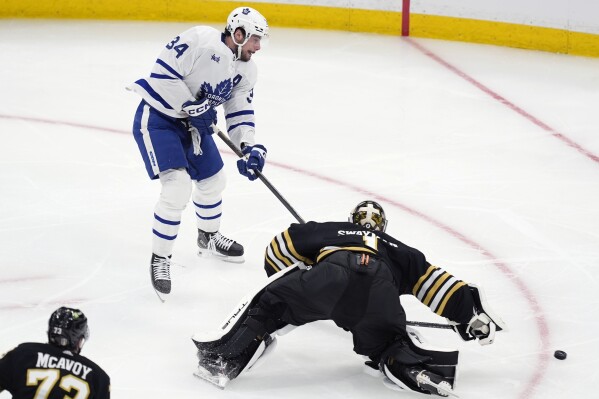 Toronto Maple Leafs' Auston Matthews (34) shoots against Boston Bruins' Jeremy Swayman (1) during the second period in Game 1 of an NHL hockey Stanley Cup first-round playoff series Saturday, April 20, 2024, in Boston. (AP Photo/Michael Dwyer)