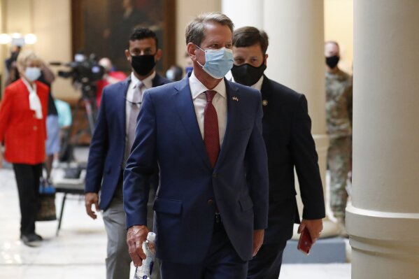 FILE - In this July 17, 2020, file photo, Georgia Gov. Brian Kemp returns to his office after giving a coronavirus briefing at the Capitol in Atlanta. Kemp says he's withdrawing a request for an emergency order that would block Atlanta from ordering people to wear masks in public or imposing other restrictions related to the COVID-19 pandemic. (AP Photo/John Bazemore, File)