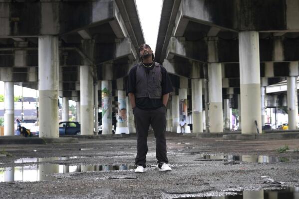 Edward Buckles, Jr., a New Orleans native who was 13 when Hurricane Katrina hit and directed the documentary "Katrina Babies," poses underneath the Claiborne Avenue overpass for a photo in the city on Friday, Aug. 19, 2022. The film looks at how a generation of New Orleans residents coming of age after Hurricane Katrina, are reconciling with the catastrophic storm that transformed their lives. (AP Photo/Chansey Augustine)