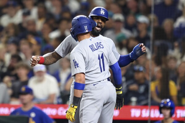 Los Angeles Dodgers' Miguel Rojas (11) celebrates with Jason Heyward after hitting a two-run home run against the Seattle Mariners during the fourth inning of a baseball game Friday, Sept. 15, 2023, in Seattle. (AP Photo/Maddy Grassy)