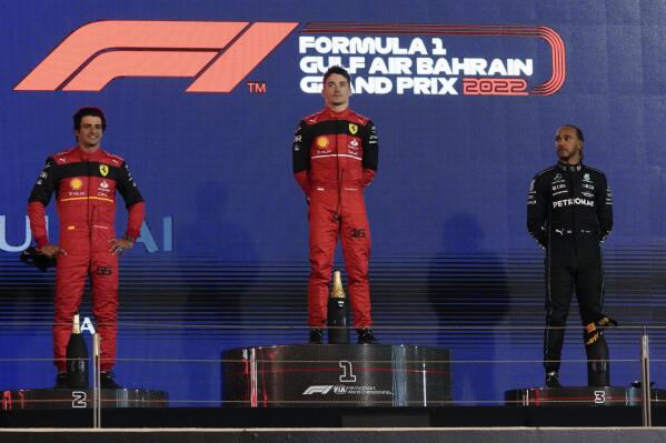 From the left, second placed Ferrari driver Carlos Sainz of Spain, first placed Ferrari driver Charles Leclerc of Monaco and third placed Mercedes driver Lewis Hamilton of Britain stand on the podium after the Formula One Bahrain Grand Prix it in Sakhir, Bahrain, Sunday, March 20, 2022. (AP Photo/Hassan Ammar)